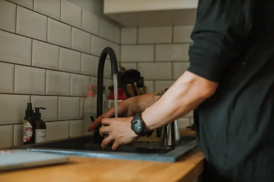 A Hartley plumber fitting a new kitchen faucet