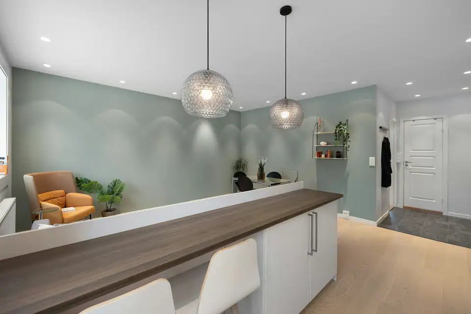 Juniper's reception: sage walls, an armchair and morning light
