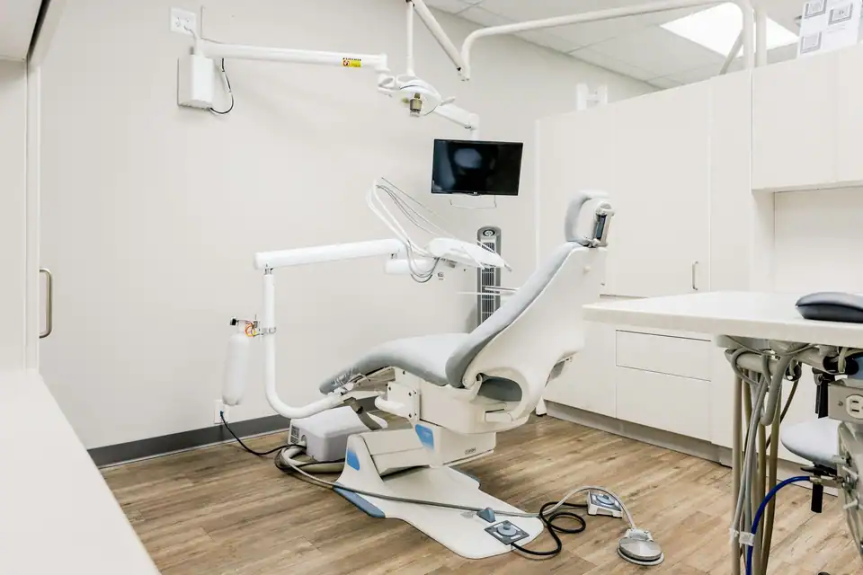 A treatment room with a window and pale wood floor