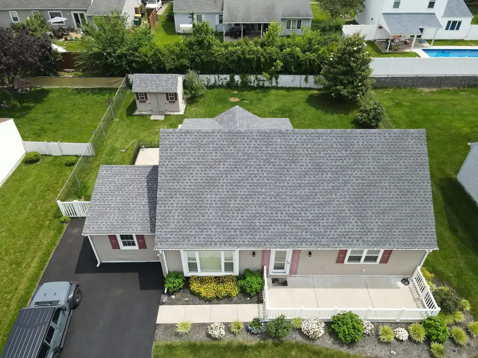 Aerial view of a grey shingle roof on a suburban house