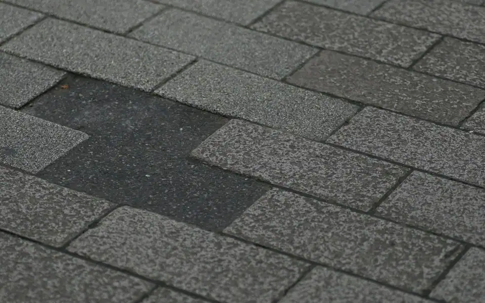 Hail-damaged asphalt shingles with a tab torn clean off